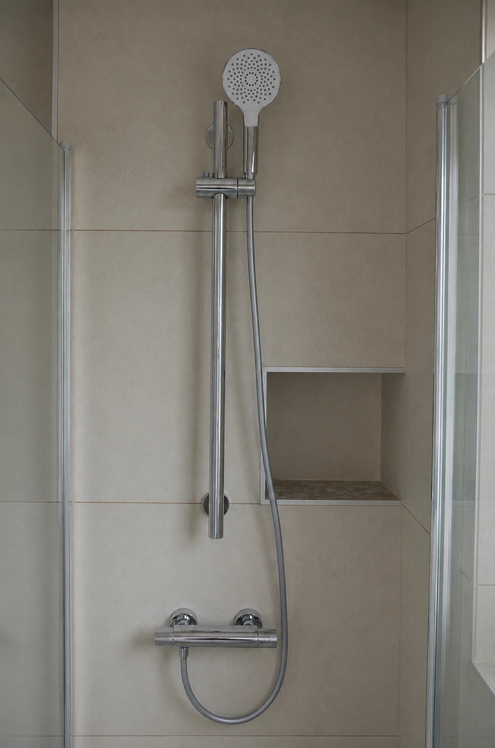 Helles Bad mit beleuchtetem Rundspiegel, Badewanne und terrazzoartigem Boden
