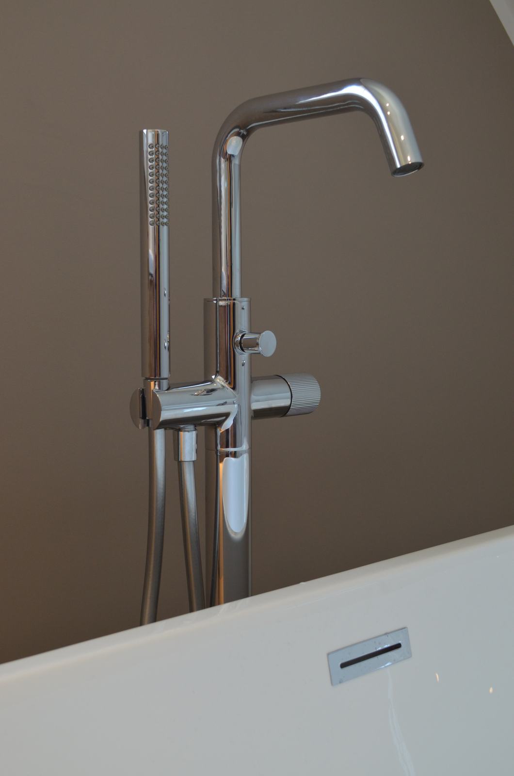 Freistehende Armatur neben einer Badewanne